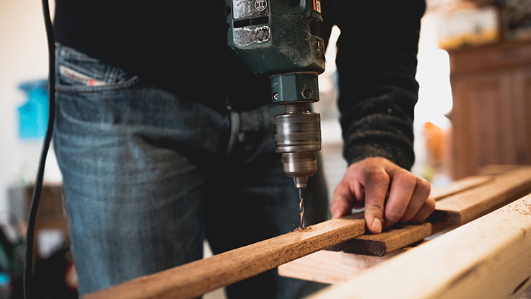 Man drilling hole in wood